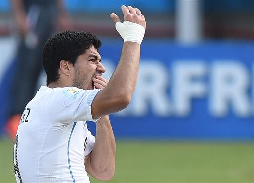 Uruguay forward Luis Suarez puts his hand to his mouth after clashing with Italy's defender Giorgio Chiellini during a Group D football match between Italy and Uruguay at the Dunas Arena in Natal during the 2014 FIFA World Cup on June 24, 2014. Uruguay won 1-0. AFP