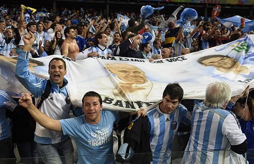 Argentine fans celebrate with a picture of Pope Francis at the end of the semi-final football match between Netherlands and Argentina of the FIFA World Cup at The Corinthians Arena in Sao Paulo on July 9, 2014. AFP