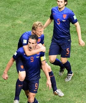 Netherlands' forward and captain Robin van Persie (front) celebrates with his teammates Netherlands' defender Dirk Kuyt (C) and Netherlands' defender Daley Blind after scoring a penalty during the third place play-off football match between Brazil and Netherlands during the 2014 FIFA World Cup at the National Stadium in Brasilia on July 12, 2014. AFP