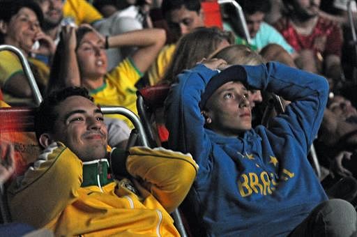 Brazilian fans watch the FIFA World Cup third-place match between Brazil and the Netherlands on a screen during the Fan Fest at Copacabana beach in Rio de Janeiro, Brazil, on July 12, 2014. Germany and Argentina will play the final on Sunday. AFP