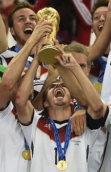 Germany's defender and captain Philipp Lahm holds up the World Cup trophy as he celebrates with his teammates after they won the 2014 FIFA World Cup final football match between Germany and Argentina 1-0 following extra-time at the Maracana Stadium in Rio de Janeiro, Brazil, on July 13, 2014. AFP
