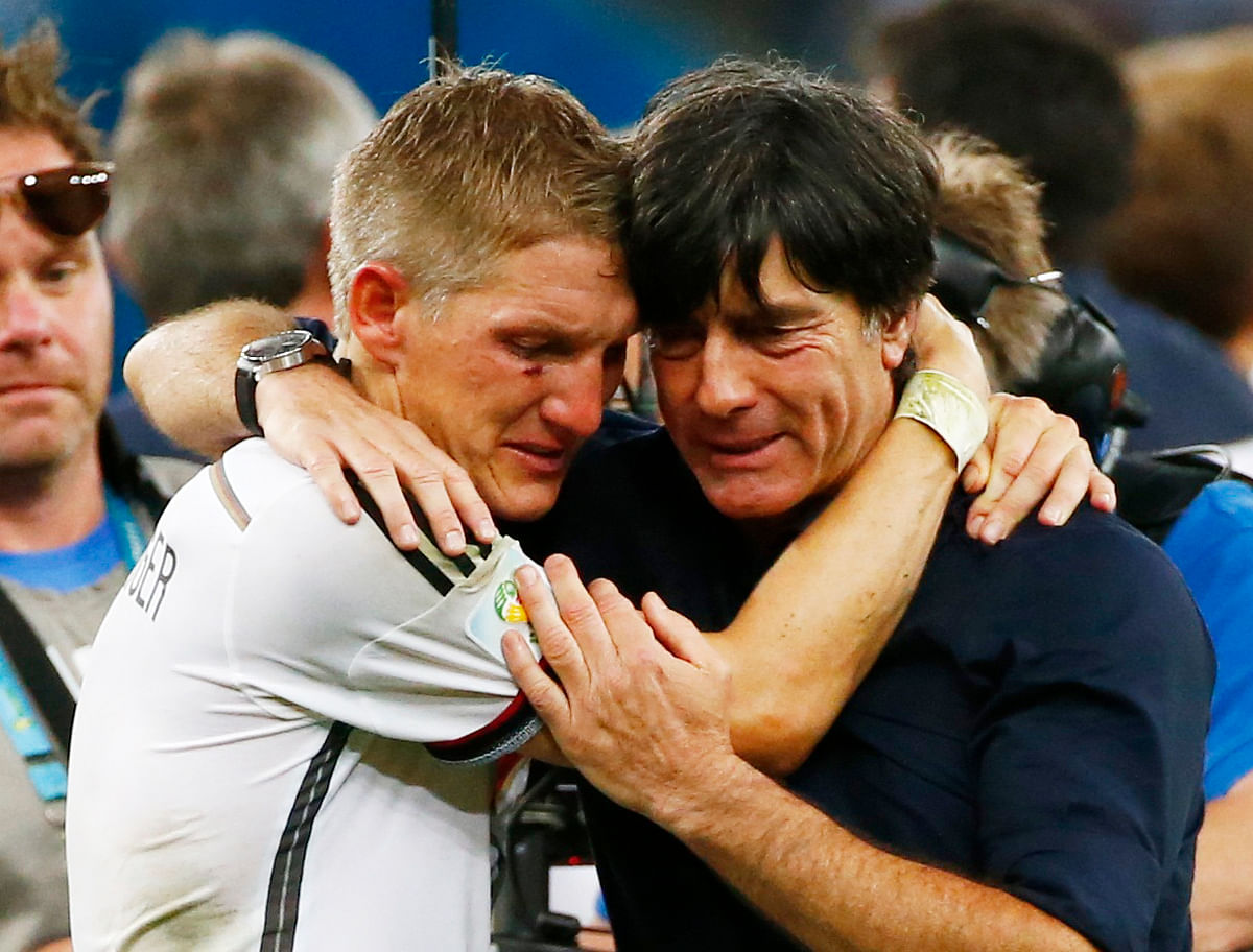 Germany's Bastian Schweinsteiger (L) embraces coach Joachim Loew as they celebrate their win against Argentina after their 2014 World Cup final at the Maracana stadium in Rio de Janeiro on July 13, 2014. Reuters