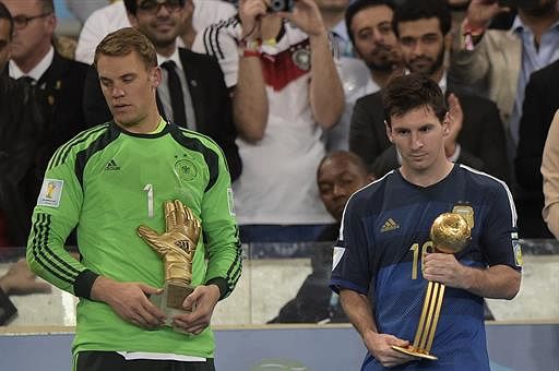 Germany's goalkeeper Manuel Neuer (L) and Argentina's forward and captain Lionel Messi (R) hold their respective trophies of 'Golden Glove' and 'Golden Ball' during a presentation ceremony after the final football match between Germany and Argentina for the FIFA World Cup at The Maracana Stadium in Rio de Janeiro on July 13, 2014. AFP