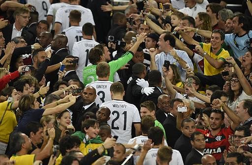 Germany's team-mates (C) walk up to receive the World Cup trophy after winning the 2014 FIFA World Cup final football match between Germany and Argentina 1-0 following extra-time at the Maracana Stadium in Rio de Janeiro, Brazil, on July 13, 2014. AFP