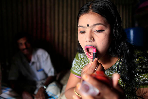 A file shows a teenage sex-worker is applying lipstick on her lips at Kandapara brothel in Tangail on March 5, 2012. Photo: Reuters