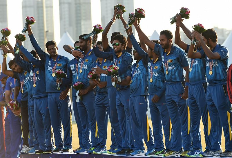 Sri Lanka's cricket team celebrate on the podium with their gold medals during the awards ceremony after beating Afghanistan in the men's cricket final of the 17th Asian Games in Incheon on October 3, 2014. AFP