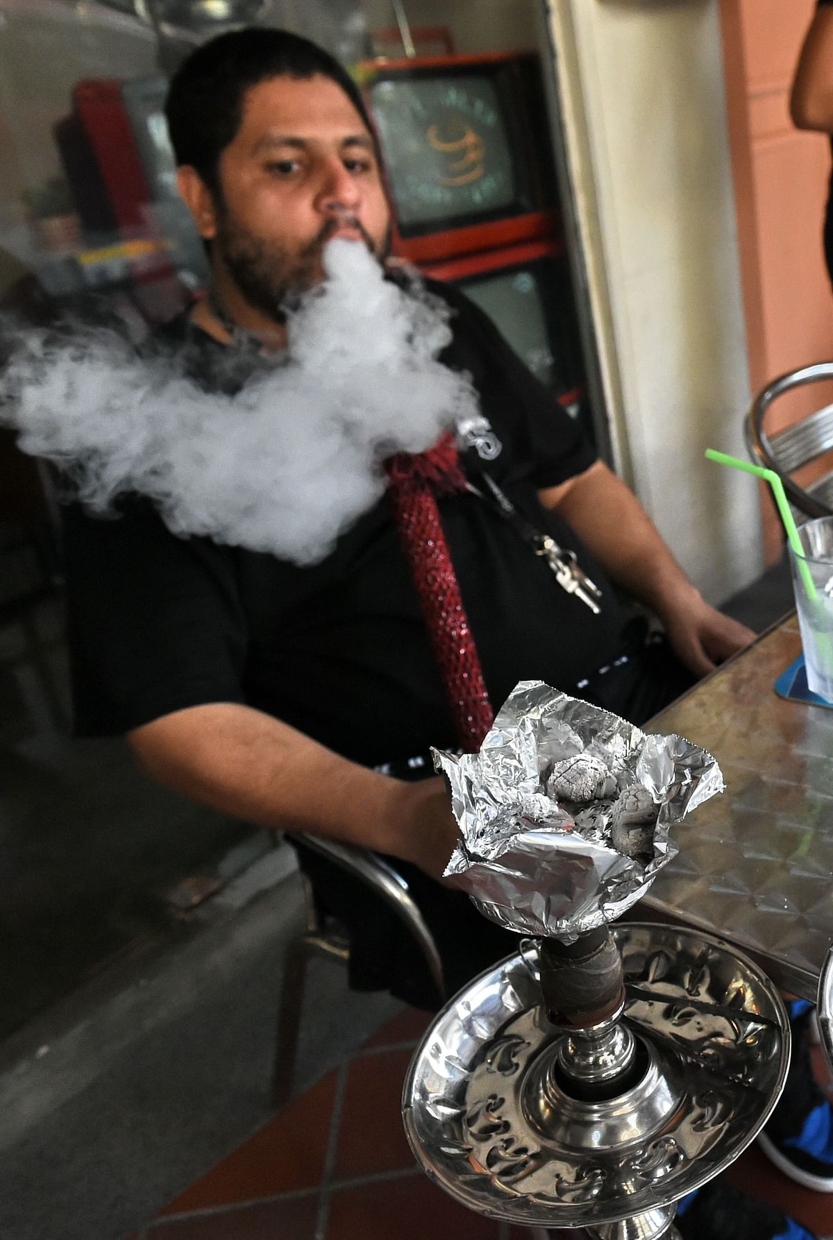 A customer smokes a shisha or 'hookah' pipe at a cafe in Singapore. Photo: AFP