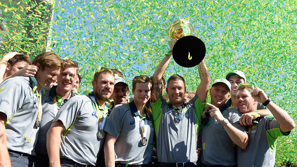 Australian captain Michael Clarke holds the 2015 Cricket World Cup trophy as he poses with the team during a public event to celebrate their victory in the world cup in Melbourne on March 30, 2015. Photo : AFP