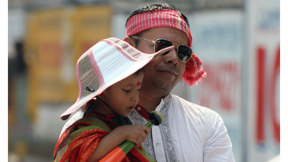 A child with her father enjoys the Baishakh celebration. Photo: Zahidul Karim