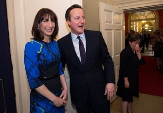 Britain's Prime Minister and Leader of the Conservative Party David Cameron (2nd L) and his wife Samantha are greeted by staff upon entering 10 Downing Street in London on May 8, 2015, after visiting Queen Elizabeth II, a day after the British general election. Photo: AFP