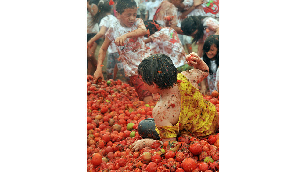 Children participate in the ninth annual tomato fight festival, known as "tomatina", in Sutamarchan, Boyaca department, Colombia, on June 7, 2015. Photo: AFP