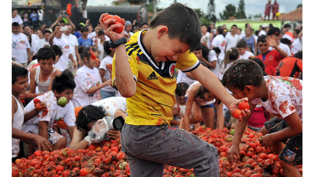 Children participate in the ninth annual tomato fight festival, known as "tomatina", in Sutamarchan, Boyaca department, Colombia, on June 7, 2015. Photo: AFP