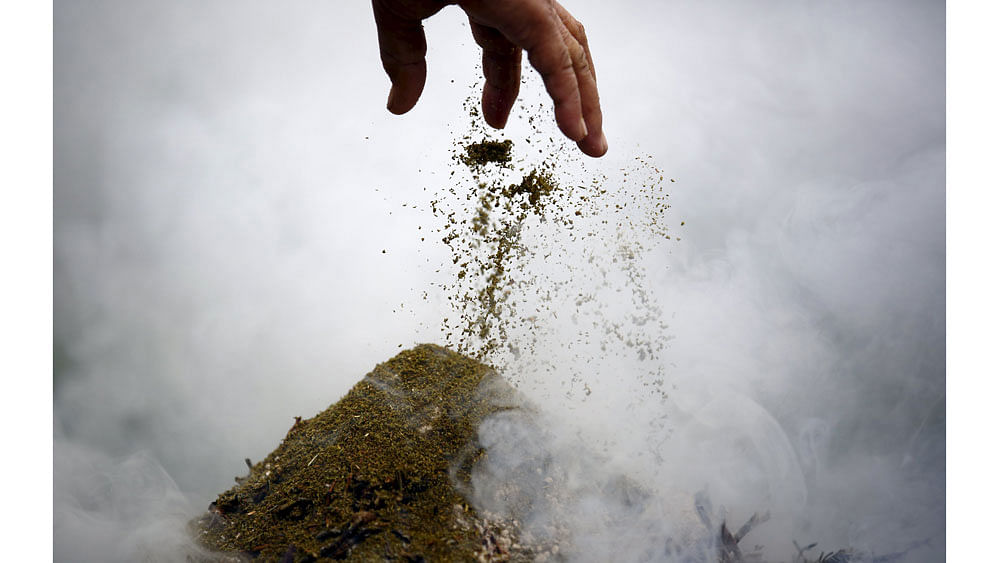 A woman offers incense while offering prayers during a function organized to mark the 80th birthday celebration of Dalai Lama in Kathmandu July 6, 2015. Photo: Reuters