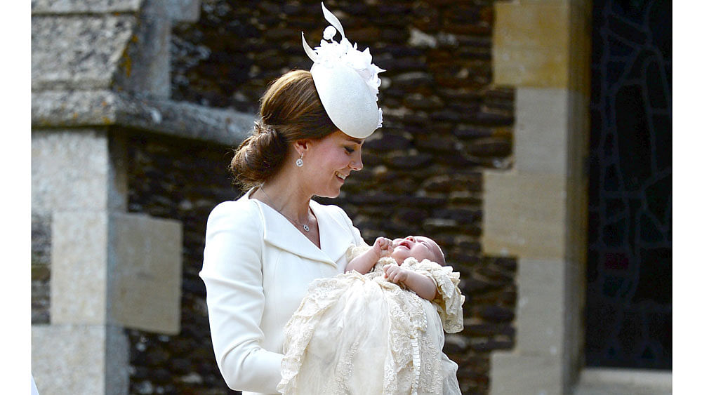 Catherine, the Duchess of Cambridge, carries her daughter Princess Charlotte into the Church of St Mary Magdalene on the Sandringham Estate for the princess