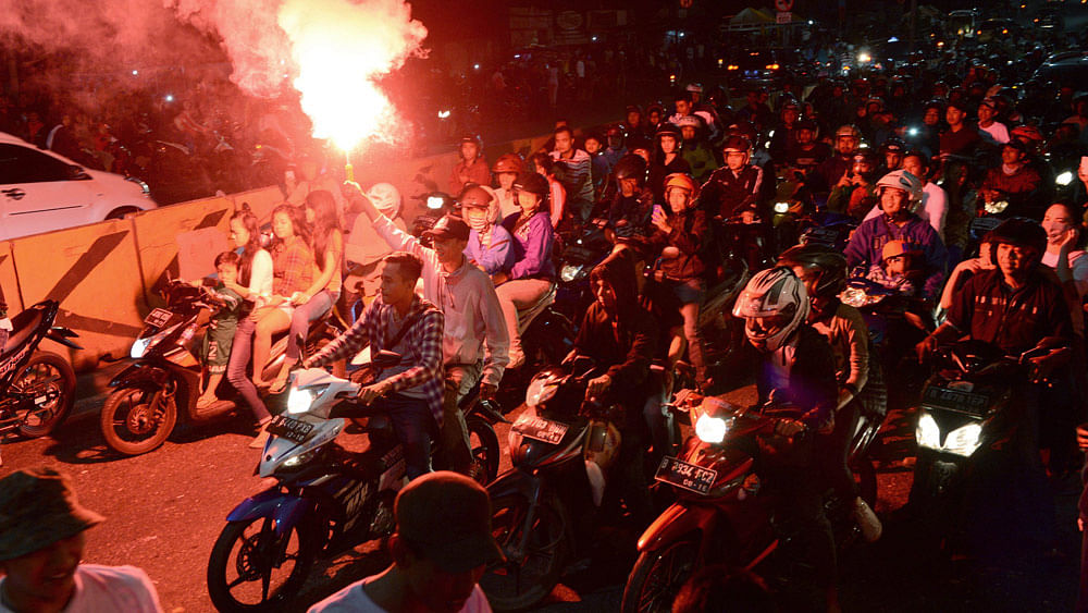 Indonesians light fireworks as they ride motorbikes during a festive street gathering in Jakarta on July 16, 2015, on the eve of Eid al-Fitr. Photo: AFP