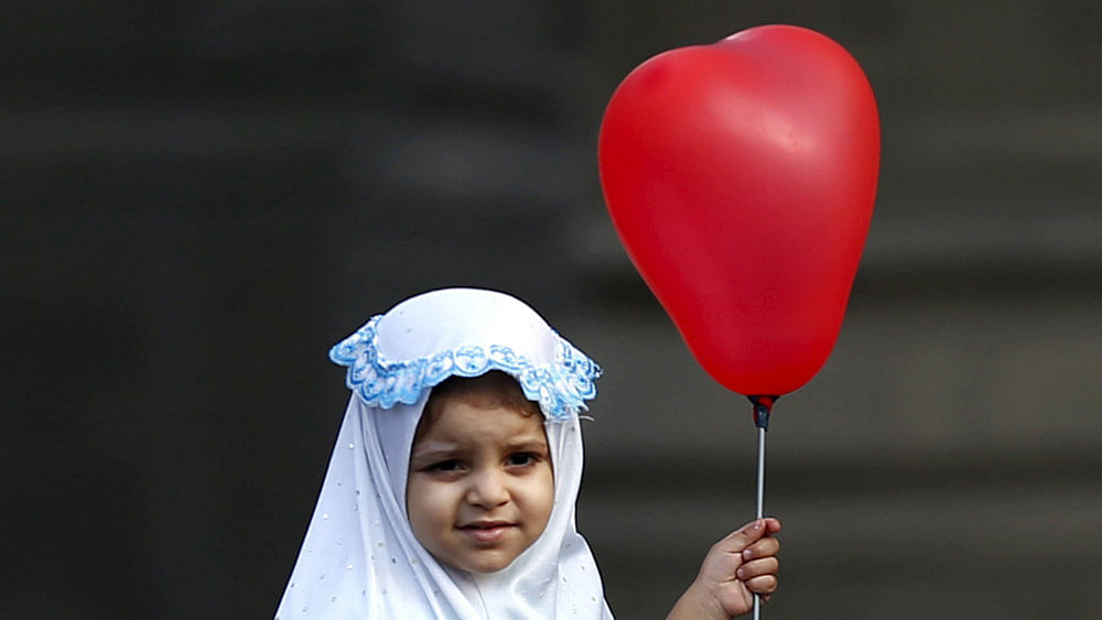 A Muslim girl holds a ballon after Eid-al-Fitr prayers in the old Islamic area of Cairo, Egypt, July 17, 2015. Photo: Reuters