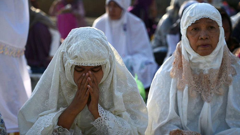 Indonesian women offer morning prayers during Eid al-Fitr celebrations at the Sunda Kelapa port in Jakarta on July 17, 2015.Photo:AFP