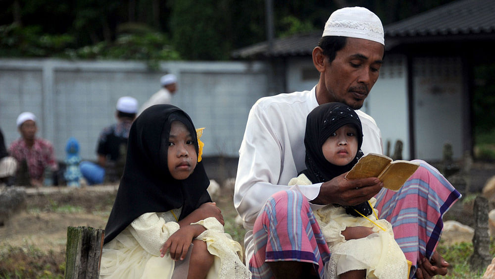 Thai Muslims pray at a cemetery on the first day of Eid al-Fitr celebrations in Thailand