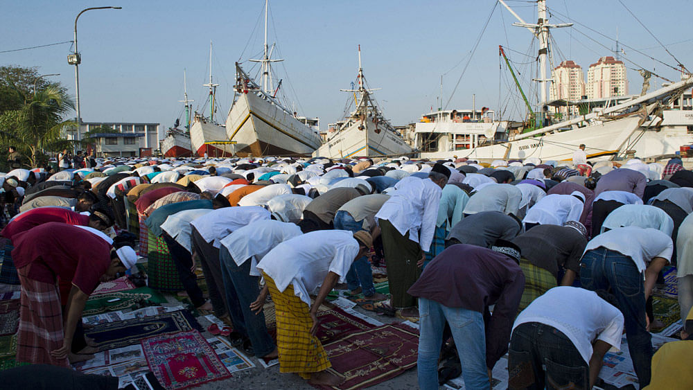 Indonesians offer morning prayers during Eid al-Fitr celebrations at the Sunda Kelapa port in Jakarta on July 17, 2015.Photo:AFP