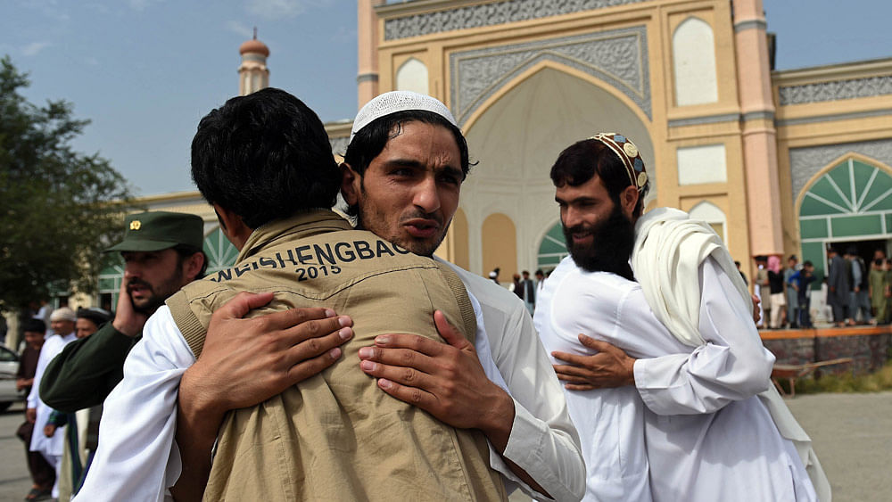 Afghan devotees greet each other after offering prayers at the start of the Eid al-Fitr holiday. Photo:AFP