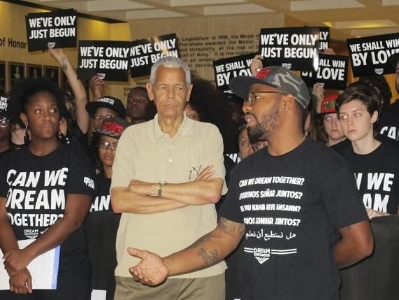 Julian Bond, former NAACP chairman (C), listens as Phillip Agnew, executive director of the Dream Defenders (R), announces an end of a 31-day sit-in at the Florida State Capitol in Tallahassee, Florida, August 15, 2013. Photo: Reuters