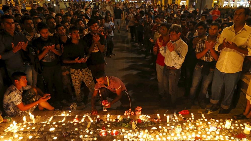 Migrants attend a candle light ceremony at a Budapest railway station in memory of 71 refugees who died in a truck found in Austria, in Budapest, Hungary August 28, 2015. Photo: Reuters