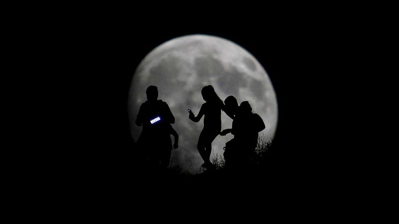 A group of hikers are seen silhouetted against the moon in Tijuana, Mexico, August 27, 2015. Photo: Reuters