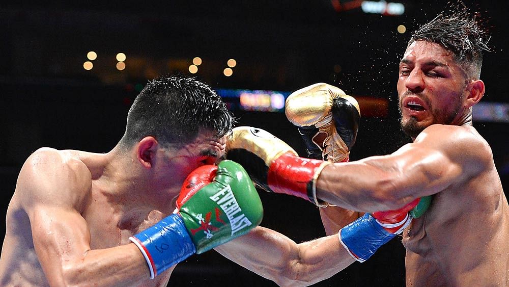 Leo Santa Cruz (green gloves/blue tape) and Abner Mares (gold gloves/red tape) during their WBC Diamond and WBA Featherweight Championship fight. Photo: Reuters