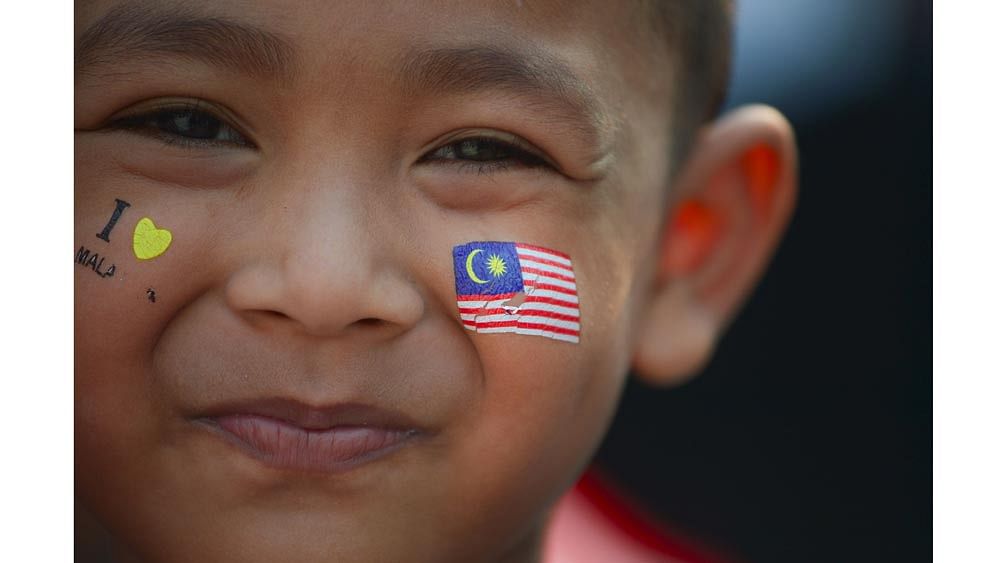 A child with his face painted with the national flag smiles during National Day celebrations at Independence Square in Kuala Lumpur on August 31, 2015. Photo: AFP