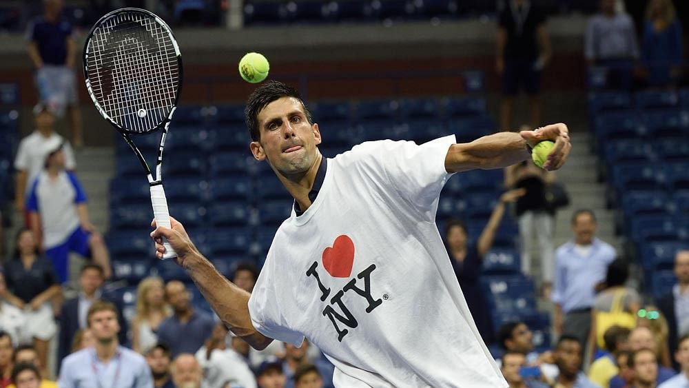 Novak Djokovic of Serbia hits balls to the fans after defeating Andreas Haider-Maurer of Austria during their US Open 2015 second round men