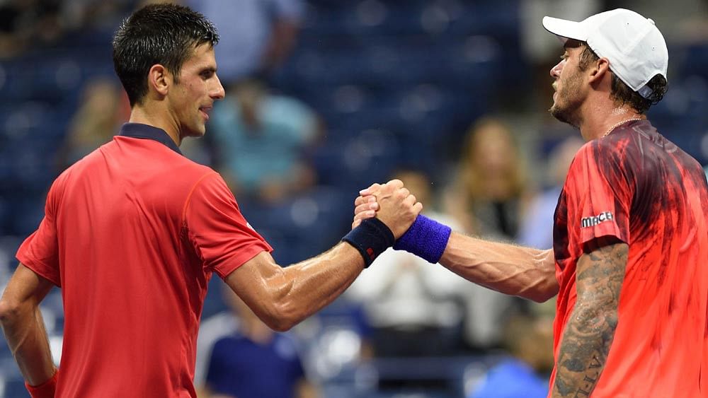 Novak Djokovic of Serbia (L) and Andreas Haider-Maurer of Austria meet at the net after their US Open 2015 second round men