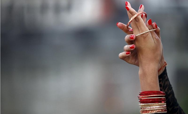 A Nepalese woman wears her bangles after taking a holy bath at the bank of Bagmati river, during the Rishi Panchami festival, in Kathmandu, Nepal September 18, 2015. Photo: Reuters