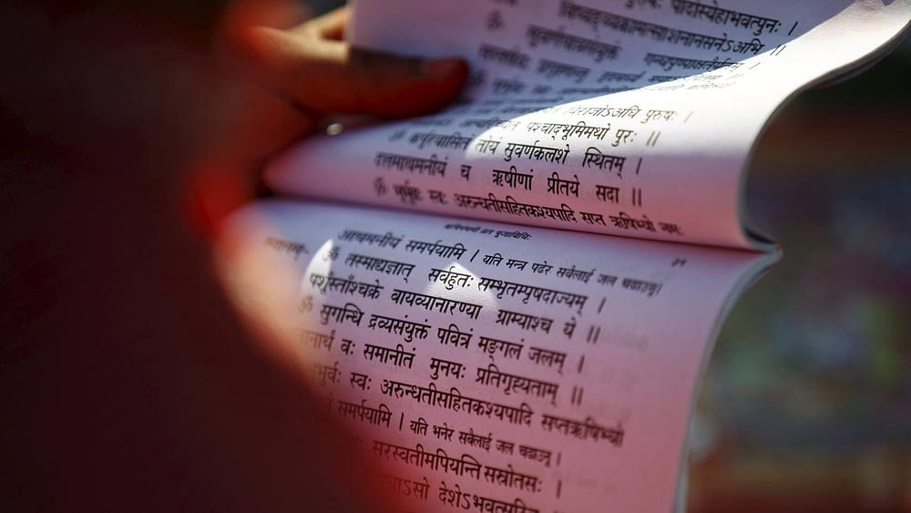 A priest holds a holy book as he recites it while performing rituals during the Rishi Panchami festival, in Kathmandu, Nepal September 18, 2015. Photo: Reuters