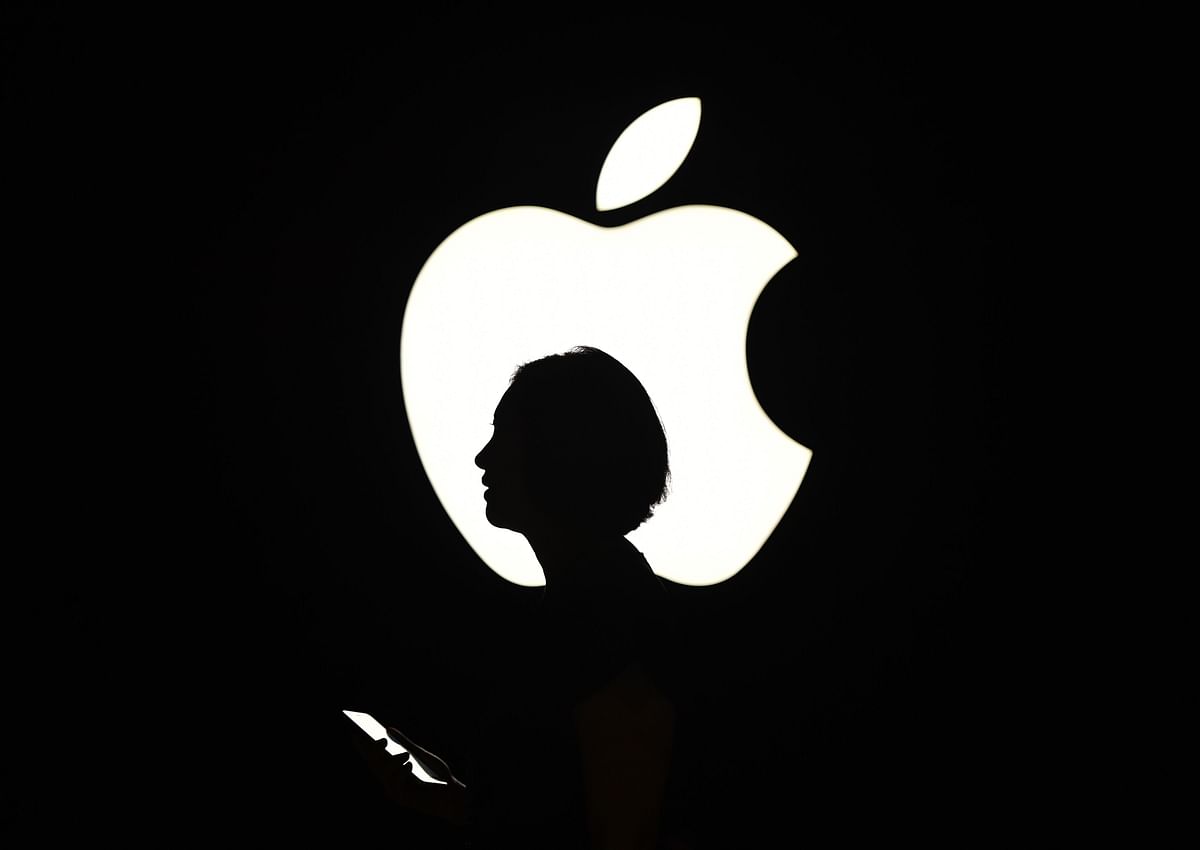 In this September 9, 2015 file photo, a reporter walks by an Apple logo during a media event in San Francisco, California on October 19, 2015. AFP