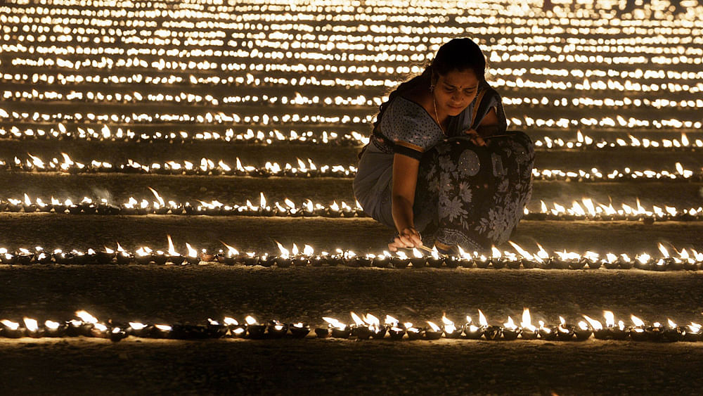 A Hindu devotee lights oil lamps as part of `Laksha Deepotsava` (celebration of a hundred thousand lights), held on the occasion of Makara Sanranti Festival in Bangalore on January 15, 2016. AFP