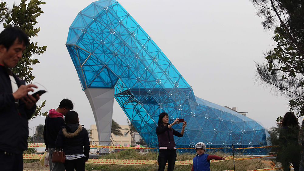 Tourists take pictures in front of a shoe-shaped church in southern Chiayi on January 11, 2016. AFP