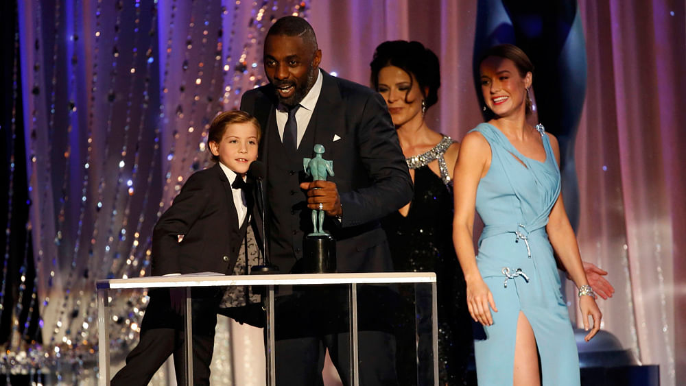 Idiris Elba accepts the award for Outstanding Performance by a Male Actor in a Television Movie or Miniseries for his role in `Luther` from presenters Jacob Tremblay (L) and Brie Larson (R) at the 22nd Screen Actors Guild Awards in Los Angeles, California January 30, 2016. Photo: Reuters