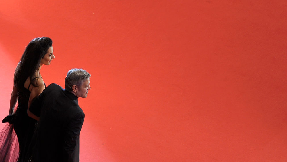 Cast member George Clooney and his wife Amal arrive on the red carpet for the screening of the movie `Hail, Caesar!`, during the opening gala of the 66th Berlinale International Film Festival, in Berlin, Germany February 11, 2016. Photo: Reuters