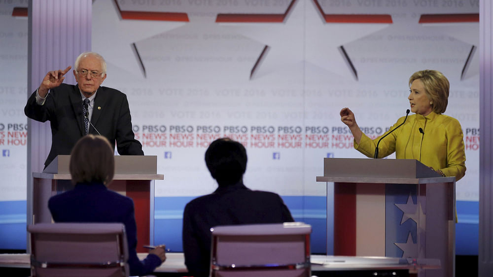 Democratic U.S. presidential candidate Senator Bernie Sanders and former Secretary of State Hillary Clinton discuss an issue at the PBS NewsHour Democratic presidential candidates debate in Milwaukee, Wisconsin, February 11, 2016. Photo: Reuters