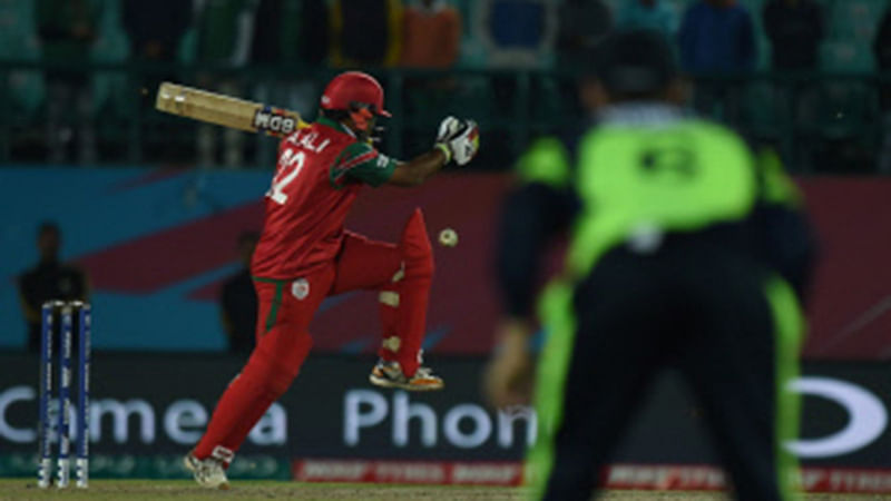 Oman`s Aamer Ali (L) is watched by an Ireland fielder as he plays a shot during the World T20 cricket tournament match between Ireland and Oman at The Himachal Pradesh Cricket Association Stadium in Dharamsala on 9 March 2016. Photo: AFP