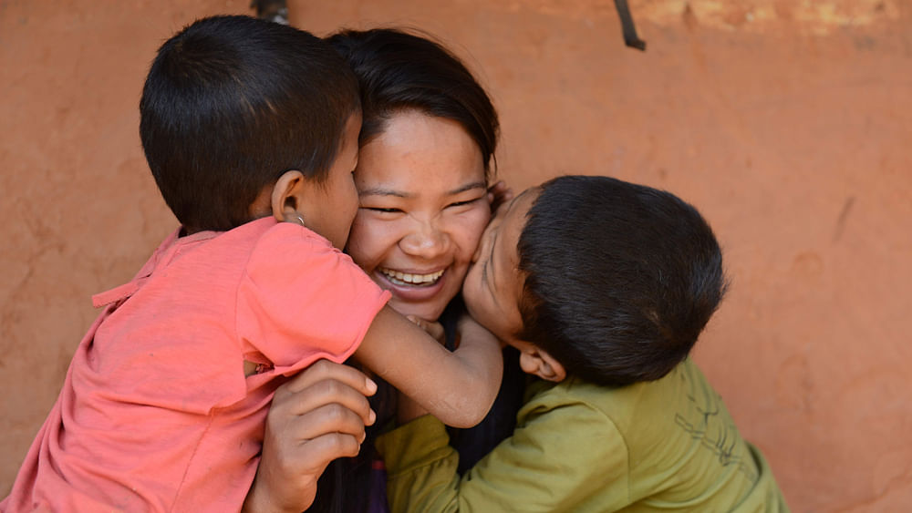 Nepalese migrant worker Sunita Magar (C), who was trafficked to Syria, being greeted by her son Bipin Magar (R) and daughter Elina Magar (L) at their home in Dhadhing district, some 100 kilometres west of Kathmandu. Photo: AFP