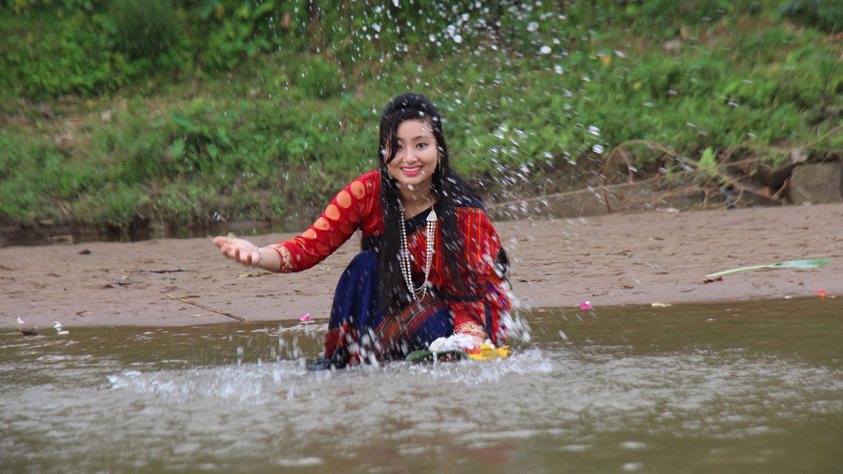 A young reveller celebrate ‘Baisabi’ festival splashing in a water body in Khagrachari on Tuesday. Photo: Prothom Alo