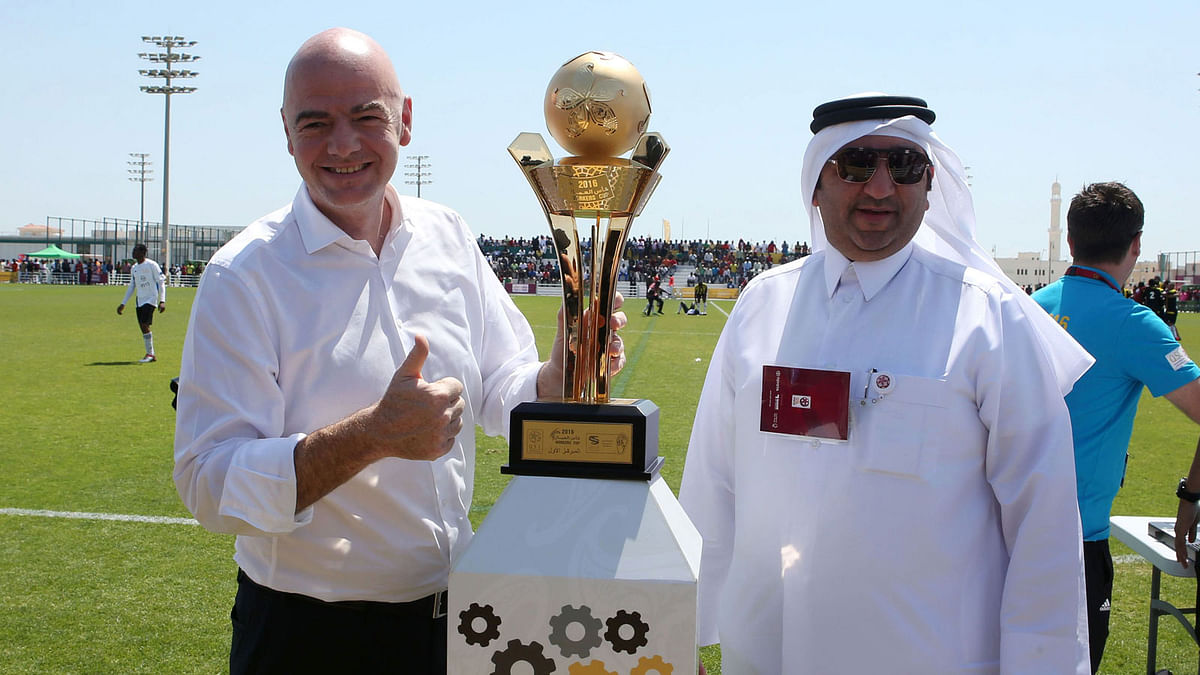 FIFA President Gianni Infantino (L) poses for a picture with the workers football cup trophy during a match ahead of a press conference in the Qatari capital Doha on April 22, 2016. AFP