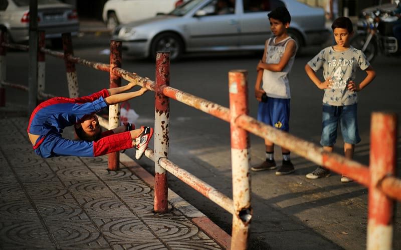 Palestinian boy Mohamad al-Sheikh, 12, who is nicknamed `Spiderman` and hopes to break the Guinness world records with his bizarre feats of contortion, demonstrates acrobatics skills in Gaza City June 2, 2016. Photo: Reuters
