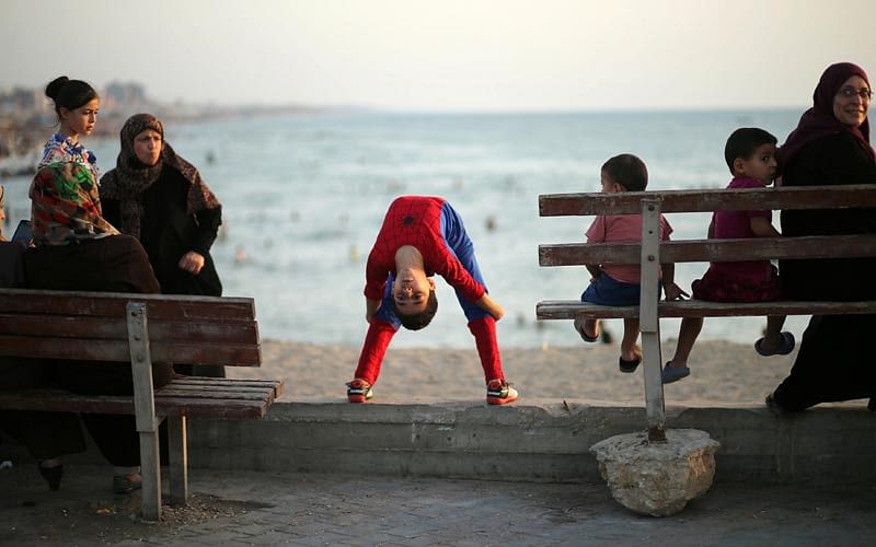 Palestinian boy Mohamad al-Sheikh, 12, who is nicknamed `Spiderman` and hopes to break the Guinness world records with his bizarre feats of contortion, demonstrates acrobatics skills on a beach in Gaza City June 2, 2016. Photo: Reuters