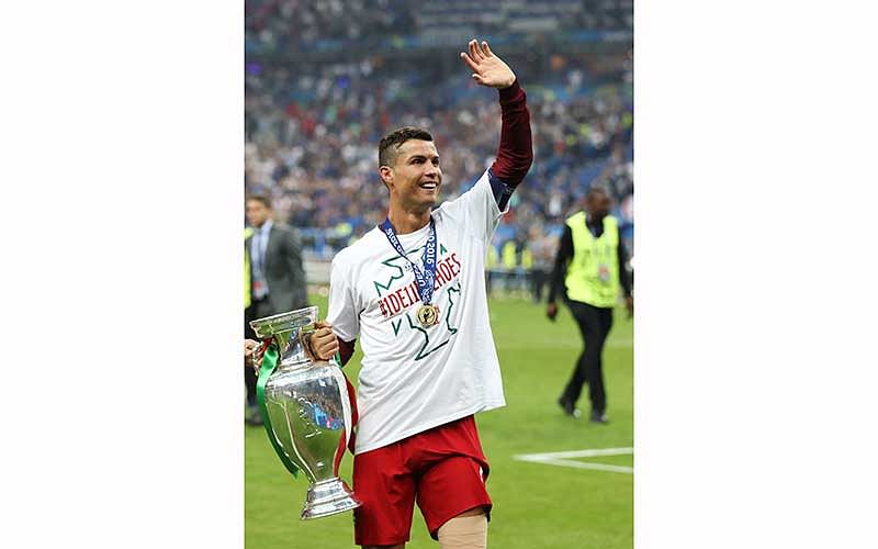 Portugal`s forward Cristiano Ronaldo poses with the trophy as he celebrates after Portugal beat France during the Euro 2016 final football match at the Stade de France in Saint-Denis, north of Paris, on July 10, 2016. Photo: AFP