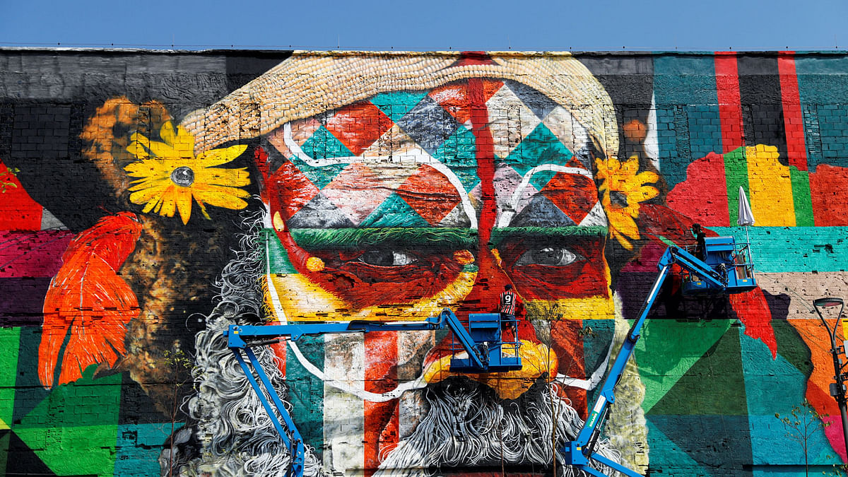 Painters work on a mural created by Brazilian artist Eduardo Kobra that when finished will cover nearly 3,000 square meters of wall space and depict indigenous faces from five continents, to welcome visitors to the Rio 2016 Olympic Games, in Rio de Janeiro, Brazil. Photo: Reuters