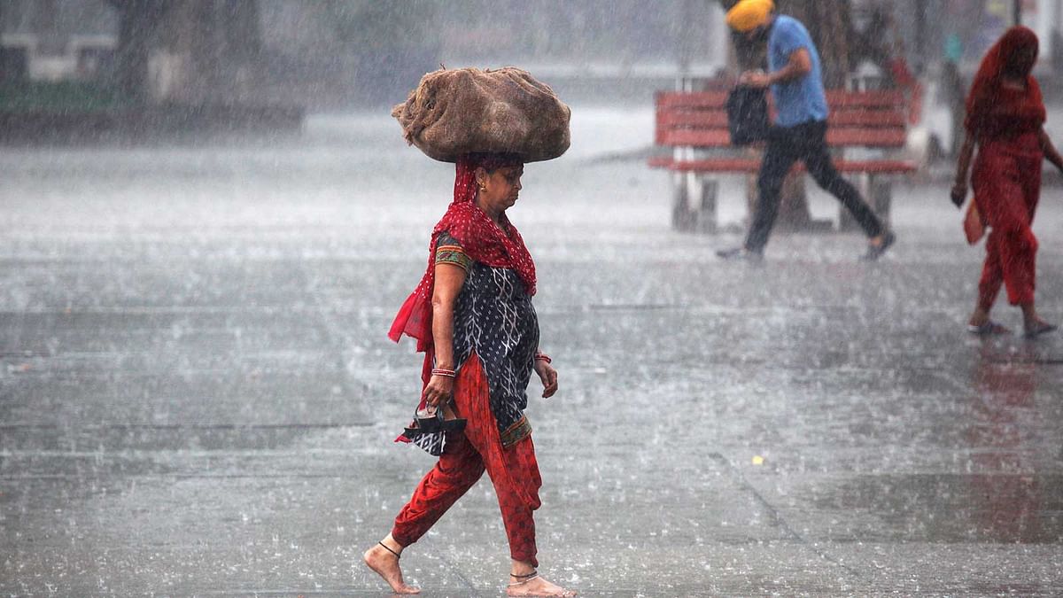 A woman carries a sack outside a market during heavy rains in Chandigarh, India, August 4, 2016. Photo: Reuters