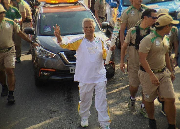 Nobel laureate professor Muhammad Yunus, flanked by volunteers, is carrying the Olympic Torch in Rio. Photo: Yunus Centre