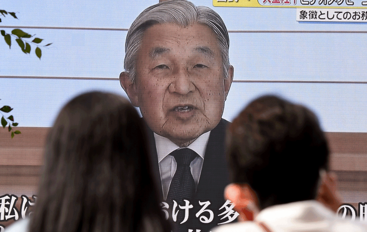 People look at a big video screen on the street as a speech by Japanese Emperor Akihito to the nation is televised in Tokyo on 8 August, 2016. Photo: AFP